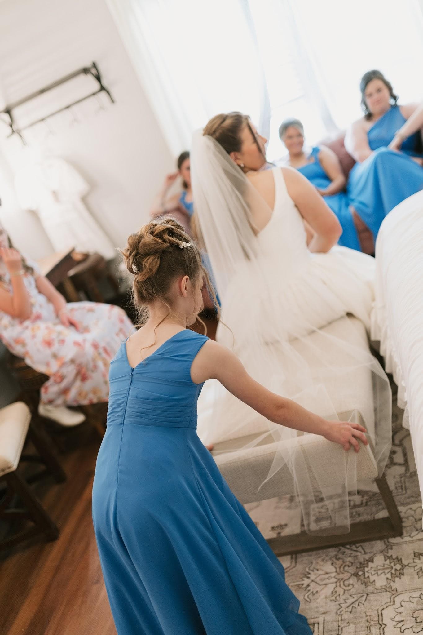 The flower girl gently fixing the bride's veil before the ceremony at The Cabin at Old Spur in Timmonsville, SC